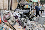 A Palestinian man inspects a damaged vehicle in the aftermath of an Israeli air strike on a house, amid Israeli-Palestinian fighting, in Gaza City, May 19, 2021. 