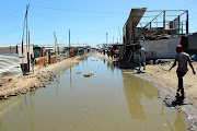 The “main road” of Marikana is a canal of stagnant water.