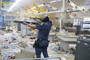 Police confront protesters in a supermarket in Alexandra, Johannesburg, amid widespread looting on Monday. President Cyril Ramaphosa on Monday warned that the violence could result in food and medicine shortages.