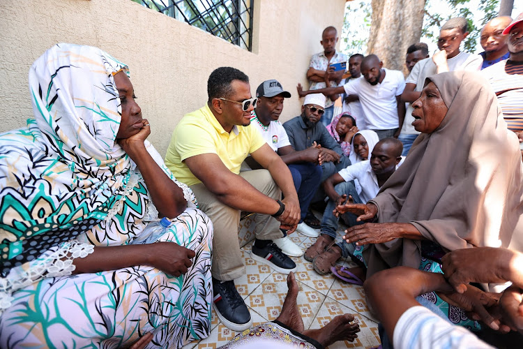 UDA vice chairman Hassan Omar with Kuuza's family outside their new house in Bofu, Likoni on Sunday.
