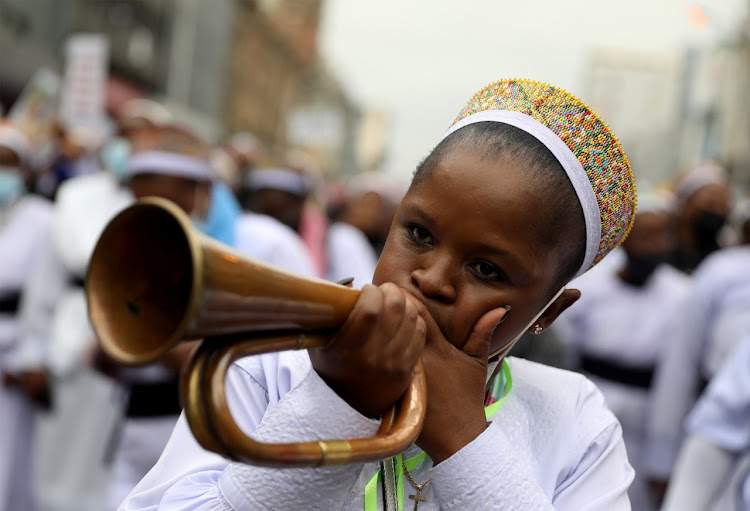 A member of the Nazareth Baptist church blows a trumpet during the peace walk on Tuesday at Durban's city centre.