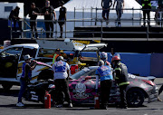 Mechanics and firefighters examining the engine of one of the cars taking place at the drifting nationals.