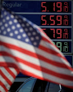 Gasoline prices are displayed at an Exxon gas station behind American flag in Edgewater, New Jersey, US, June 14, 2022.