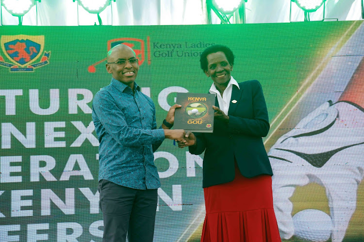 Safaricom CEO, Peter Ndegwa (left) receiving Kenya Golf Book from Sarah Hoare, Chair Kenya Ladies Golf Union (Right) during the Junior Golf Foundation/US Kids Golf Foundation partnership launch with Safaricom,