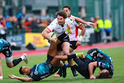 Marius Louw of Lions powers through Ashton Hewitt (left) and Max Clark of Dragons during the EPCR Challenge Cup match at Sporting Excellence in Ystrad Mynach, Wales, on January 22 2023.