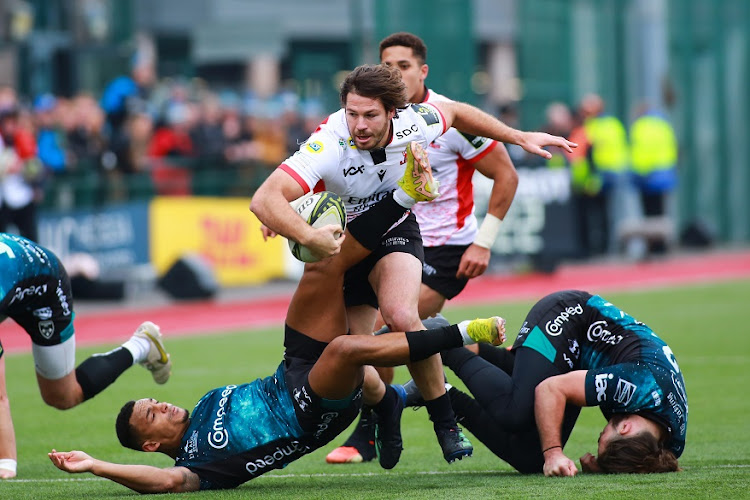 Marius Louw of Lions powers through Ashton Hewitt (left) and Max Clark of Dragons during the EPCR Challenge Cup match at Sporting Excellence in Ystrad Mynach, Wales, on January 22 2023.