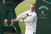 Tennis legend John McEnroe poses for photos to celebrate Robinson's 75th anniversary of their partnership with the Wimbledon Championships. File photo. 