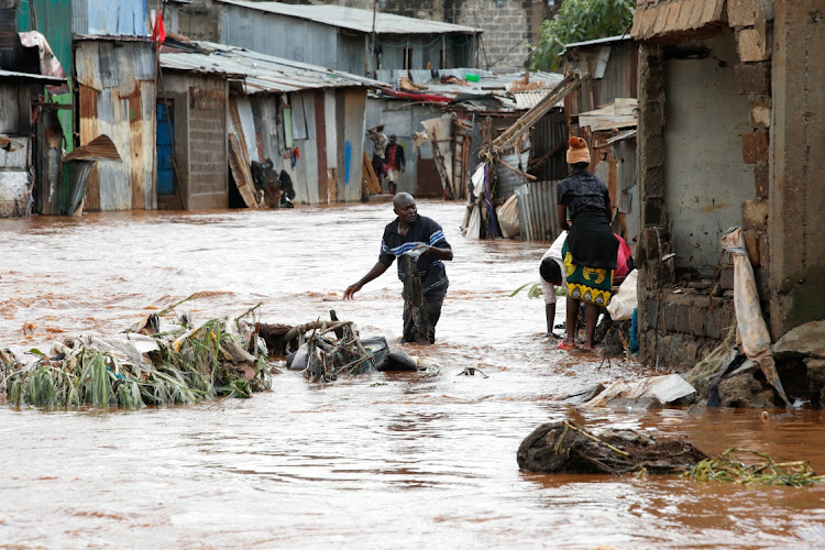 Residents wade through flood waters as they recover their belongings in Nairobi, Kenya, April 24 2024.
