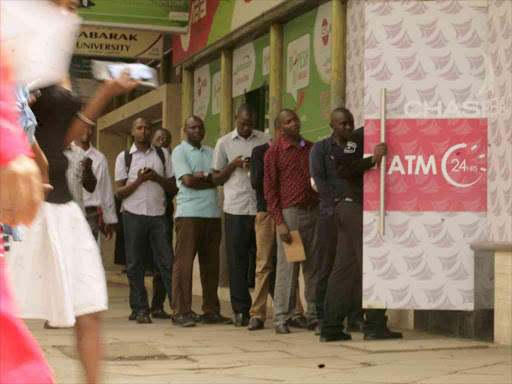 Depositors at a Chase Bank ATM along Wabera Street in Nairobi following the lender's re-opening on April 27, 2016. /Enos Teche