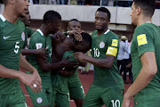 Nigeria's midfielder Victor Moses (C) celebrates with teammates after scoring a goal during the 2018 FIFA World Cup African zone group B qualifying football match between Nigeria and Algeria at the Akwa Ibom State Stadium in Uyo on November 12, 2016.