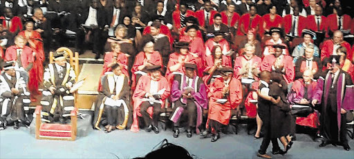 HELP AT HAND: Alex Kawondera carries disabled but determined Rhodes University graduate Thembelihle Ngcai across the stage to receive her degree in Grahamstown Pictures: SUPPLIED