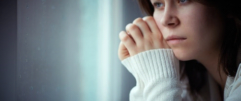 troubled female adult looking out the window