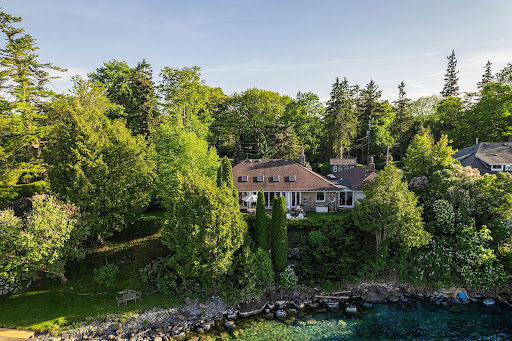 Stone house surrounded by green trees in this luxury property for sale in Jacksons Point ($2,161,893)