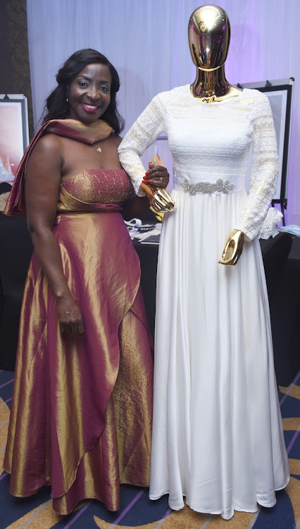 Kempinski sales director Judy Matengo stands next to a dummy dressed in a wedding gown by Ellen designs