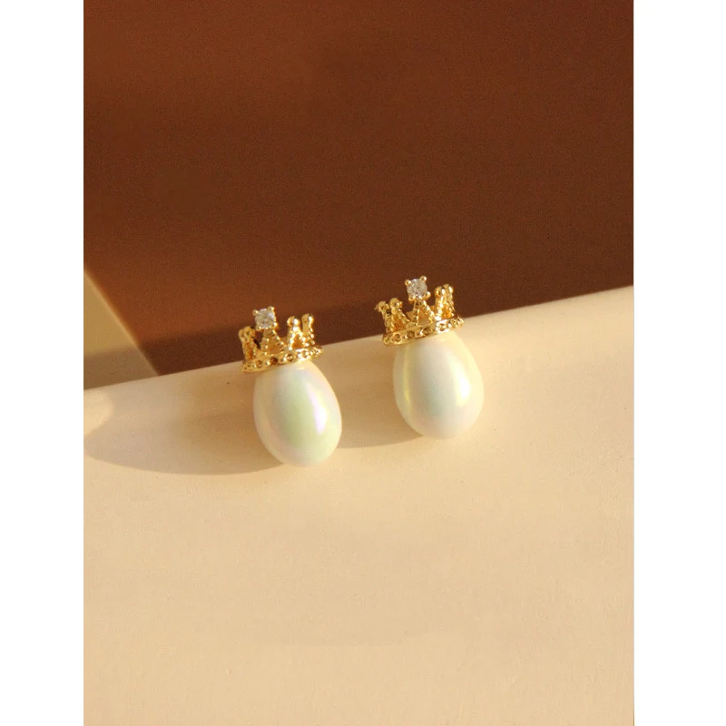 Brincos de pino de cerâmica prateada com design de coroa. Adicione um toque real e elegante ao seu visual. Perfeitos para qualquer ocasião.
