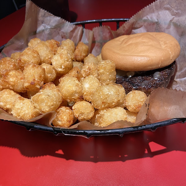 Customized gluten free burger with bacon and cheddar cheese with tater tots