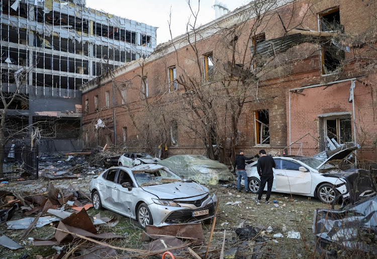 Residents check their car, which was destroyed by Russian military strikes in central Kyiv, Ukraine, October 11 2022. Picture: GLEB GARANCHICH