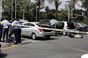 Five robbery suspects lie on the ground at a BP garage on Corlett Drive, outside the upmarket Melrose Arch lifestyle centre, on March 27 2019.