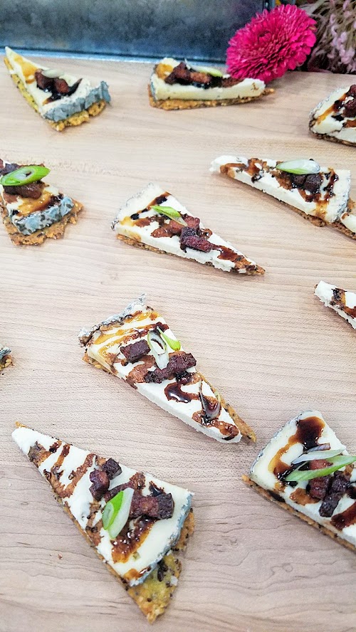 At the California Artisan Cheese Festival Best Bite Competition, Michele Wynne and Paige Icardi from Bi-Rite Market, San Francisco used Pluvius from Willapa Hills Cheese with a homemade super seed cracker, rind dust, ginger infused balsamic reduction, candied bacon, and scallions