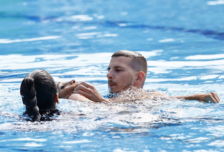 Anita Alvarez of the U.S. receives medical attention during the women's solo free final.