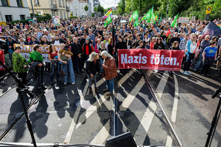 People hold a banner that reads: "Nazis kill" as they protest against recent beatings of politicians and election campaign volunteers on May 5 2024 in Dresden, Germany.