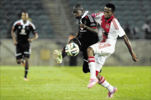 DETERMINED: Orlando Pirates winger Sifiso Myeni fights for the ball with Ajax Cape Town's Mosa Lebusa at Orlando Stadium on Saturday Photo: Gallo Images