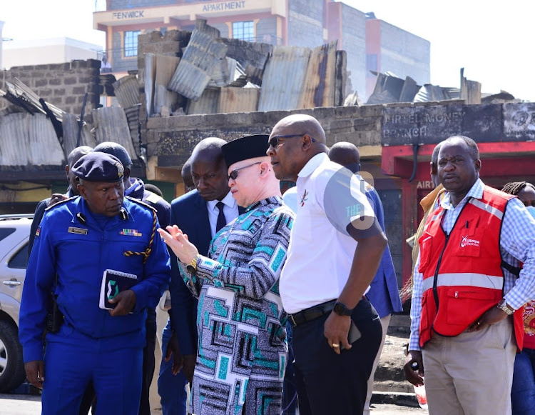 Government Spokesperson Isaac Mwaura in the company of police officers at the scene of the Embakasi fire tragedy in Nairobi on February 2, 2024