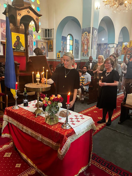 A dignitary places a candle in a sandbox during the commemoration service for the victims of the Holodomor genocide at the Orthodox Patriarchal Cathedral of Sts. Cosmas and Damian, on Valley road, Nairobi on November 25, 2023.