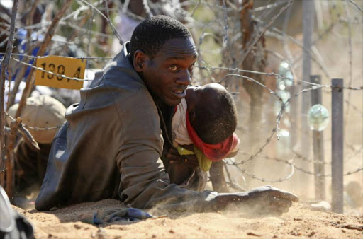 A Zimbabwean man and infant cross through the border fence into South Africa on Zimbabwe’s election day in 2008. This was at the height of the political crisis in Zimbabwe.