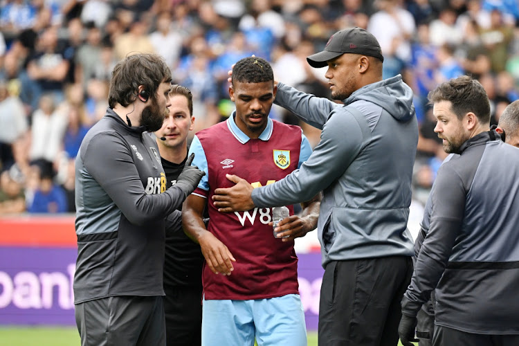 Burnley striker Lyle Foster, centre, pictured with manager Vincent Kompany, right.