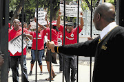 Sadtu members protest outside the Department of Basic Education headquarters in February. The union wants Basic Education Minister Angie Motshekga removed from her portfolio