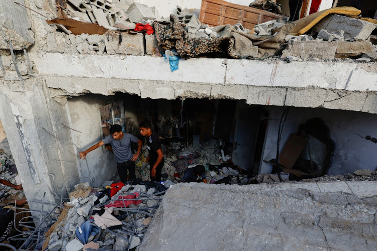 Palestinians search for casualties under the rubble of a building destroyed by Israeli strikes in Khan Younis in the southern Gaza Strip on October 17 2023.