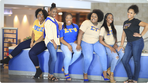 Seis miembros de la hermandad Sigma Gamma Rho, con sus letras de hermandad.