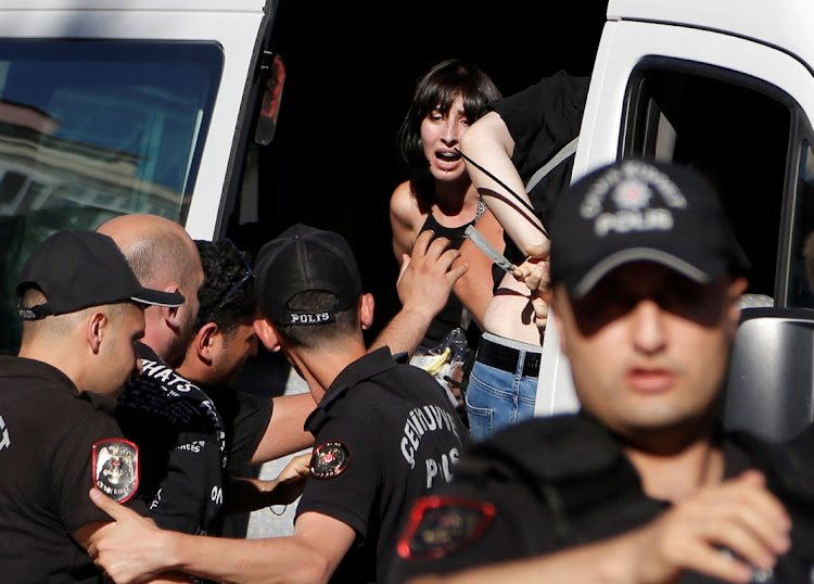 Police officers detain activists to prevent them from marching in a pride parade, which was banned by local authorities, in Ankara, Turkey July 5, 2022.