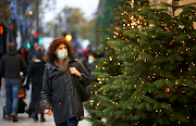 A woman walks past Christmas trees on Oxford Street, amid the coronavirus disease outbreak, in London, Britain, November 21 2020. 
