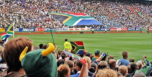 Rugby crowd unraveling a massive South African flag