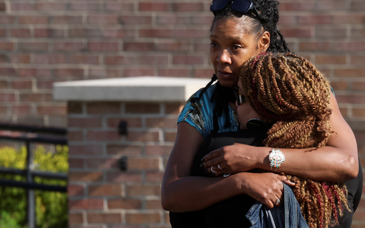 Mourners embrace each other while attending a vigil for victims of the shooting at a supermarket in Buffalo, New York, US, on May 15 2022.