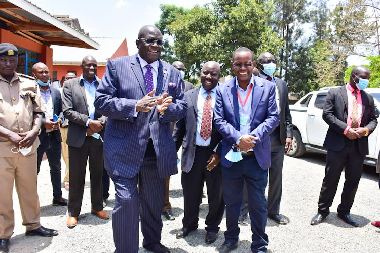 Education CS George Magoha accompanied by Kayole South High School infrastructure chairman Bernard Opondo and the school principal Daniel Ngari during the commissioning of CBC classes at Kayole South High school on Thursday, March 17.