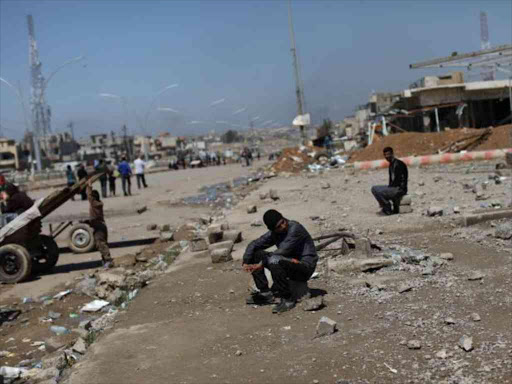 An Iraqi boy sits on a piece of debris in a street of Mosul, Iraq, April 4, 2017. REUTERS