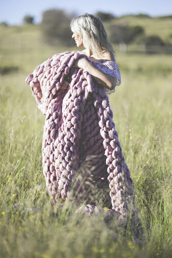 Estee Viljoen with one of her over-sized knitted blankets.
