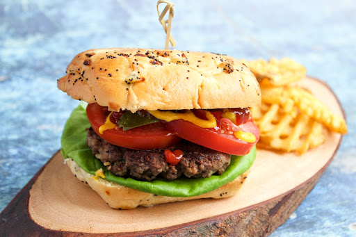 Eileen's Juicy Burgers on a bun with lettuce and tomato.