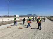 Workers prepare recycled concrete to be mixed into the new road.