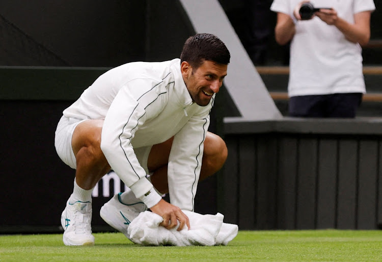 Serbia’s Novak Djokovic wiped the court with a towel after his first round match against Argentina’s Pedro Cachin was temporarily suspended due to rain in the Championships Wimbledon at All England Lawn Tennis and Croquet Club, London on July 3, 2023