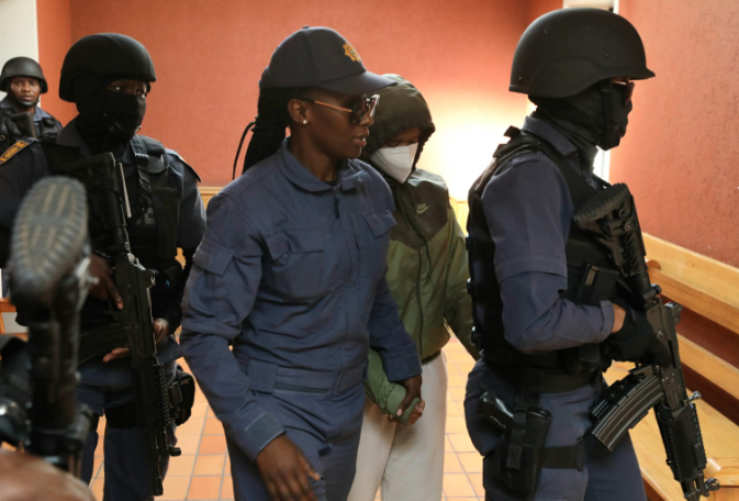 Dr Nandipha Magudumana is escorted into the Bloemfontein magistrate's court charged with murder and aiding and abetting a convict to escape. She will join her father, Zolile Cornelius Sekeleni, in the dock next week.