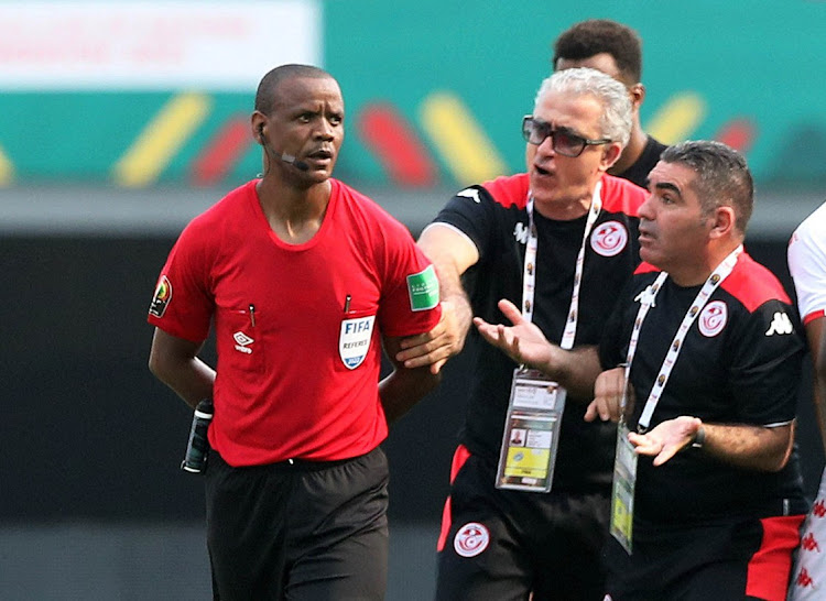 Tunisia coach Mondher Kebaier remonstrates with the referee Janny Sikazwe after the match.