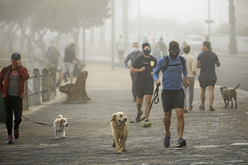 People jogging and walking with their dogs at the promenade at Sea Point, Cape Town, after the relaxation of lockdown rules. Some however didn't bother to put on masks. /Misha Jordaan/Gallo Images