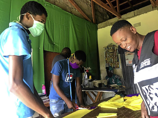 Junior Mbelekane and his granny Phumzile Mnisi are assisted by local youth to produce face masks. / Mandla Khoza