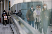 Pedestrians wearing protective masks amid the coronavirus disease (Covid-19) outbreak, make their way in Tokyo, Japan, February 2, 2021. 