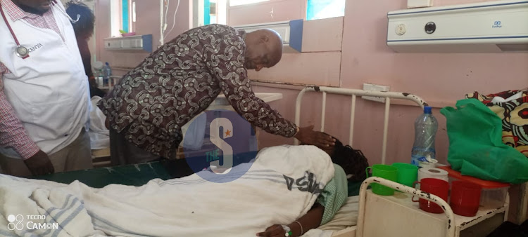 Kenyatta University Vice Chancellor Paul Wainaina comforting an injured student at the Moi County Referral Hospital ward in Voi, Taita Taveta on March 19, 2024.