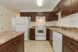 Kitchen with white appliances, wood cabinets, and stone-inspired countertops